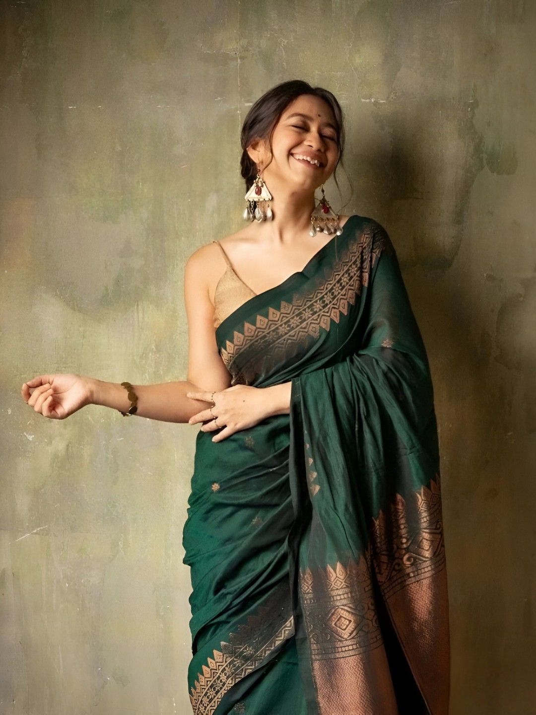 Model in a graceful green silk saree posing in palace interiors