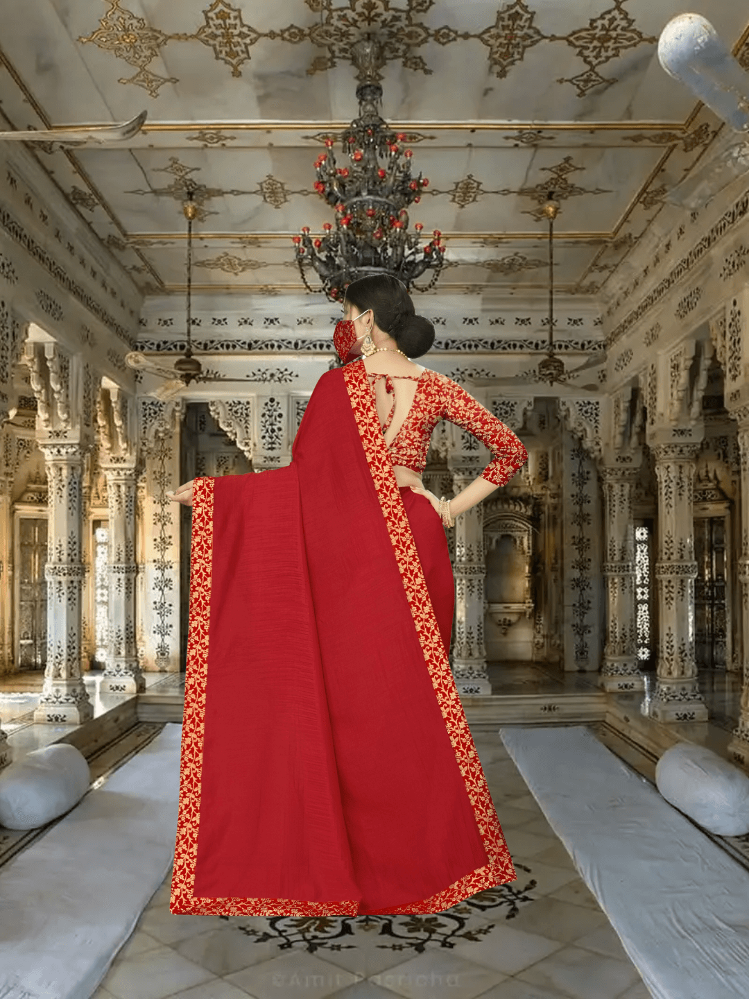 Red saree pallu cascading in regal palace room with ornate backdrop