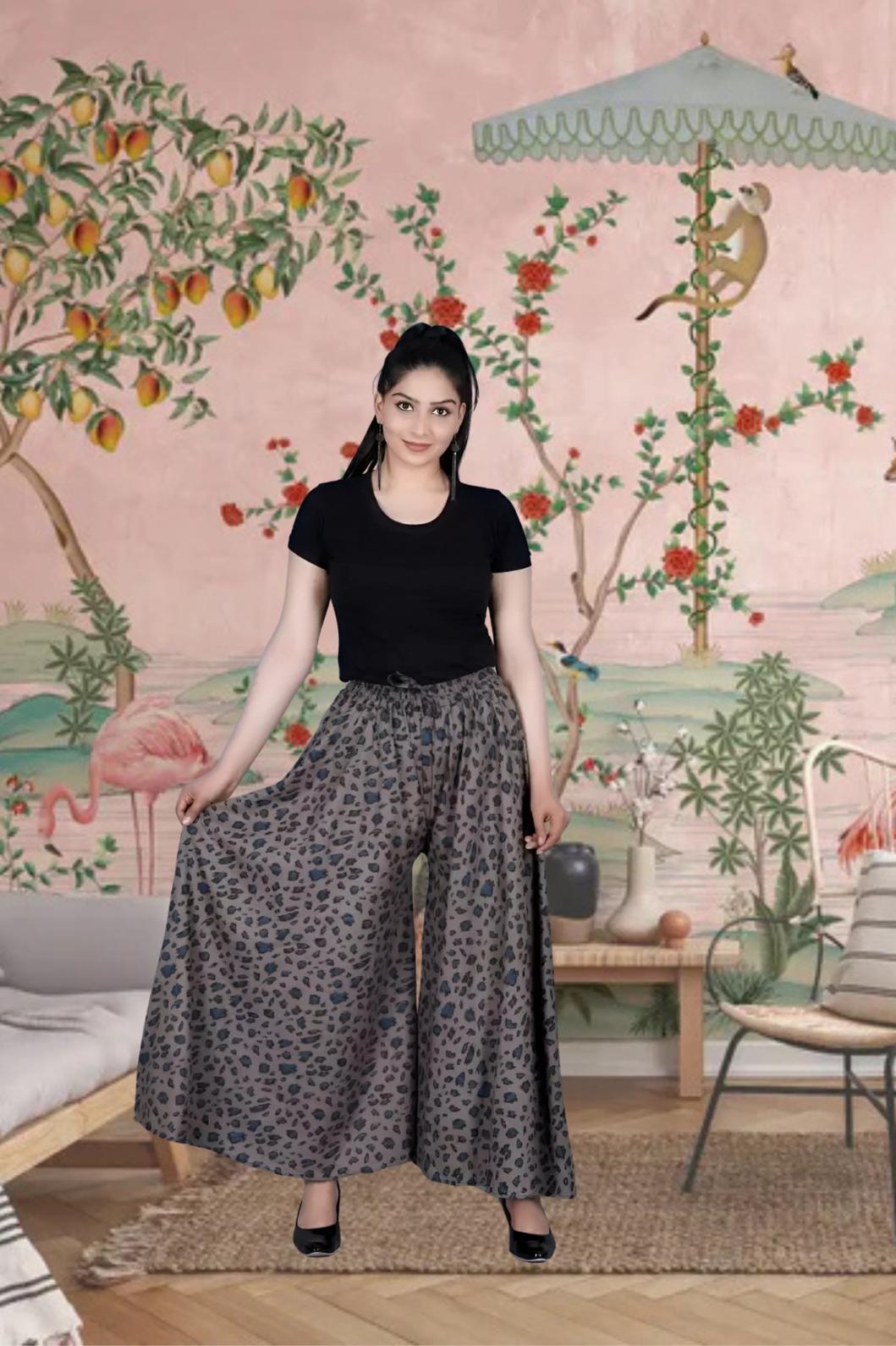 Front view of grey printed palazzo pants in palace setting