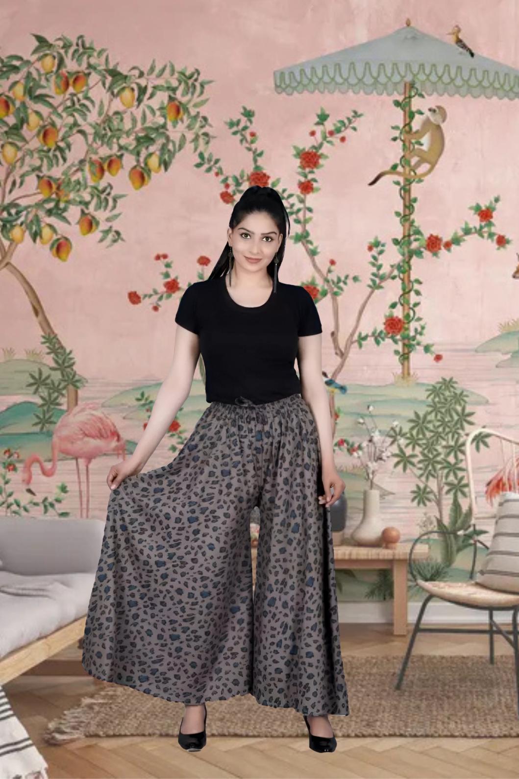 Front view of grey printed palazzo pants in palace setting