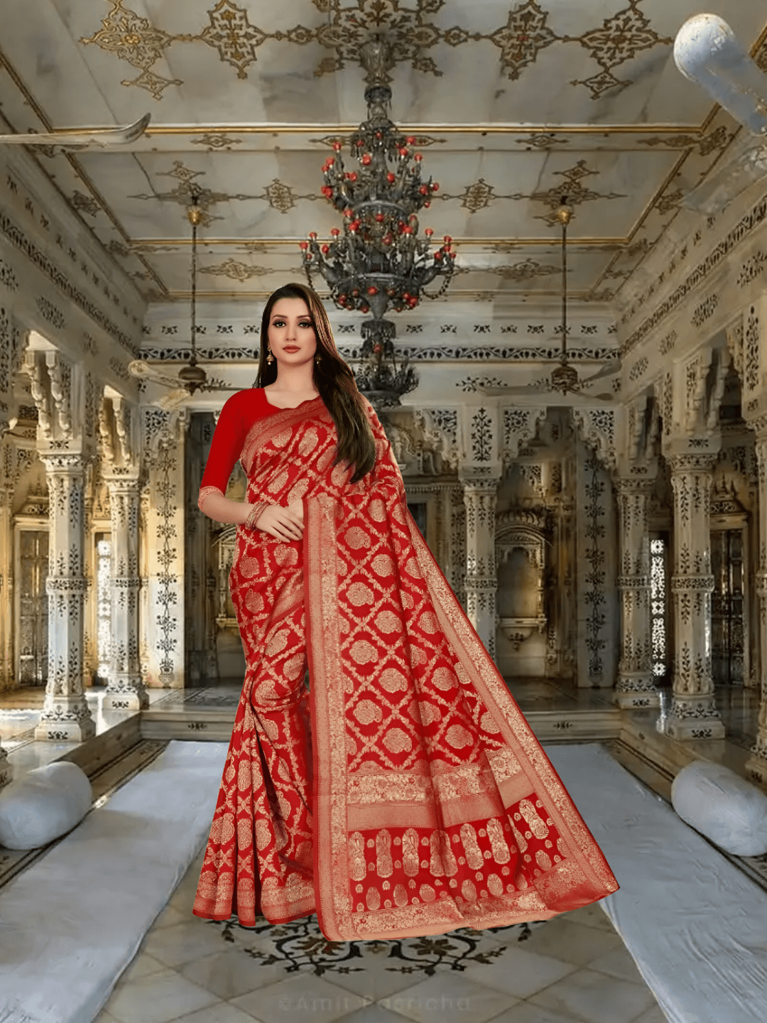 Model standing in palace archway, red saree glowing under golden chandeliers