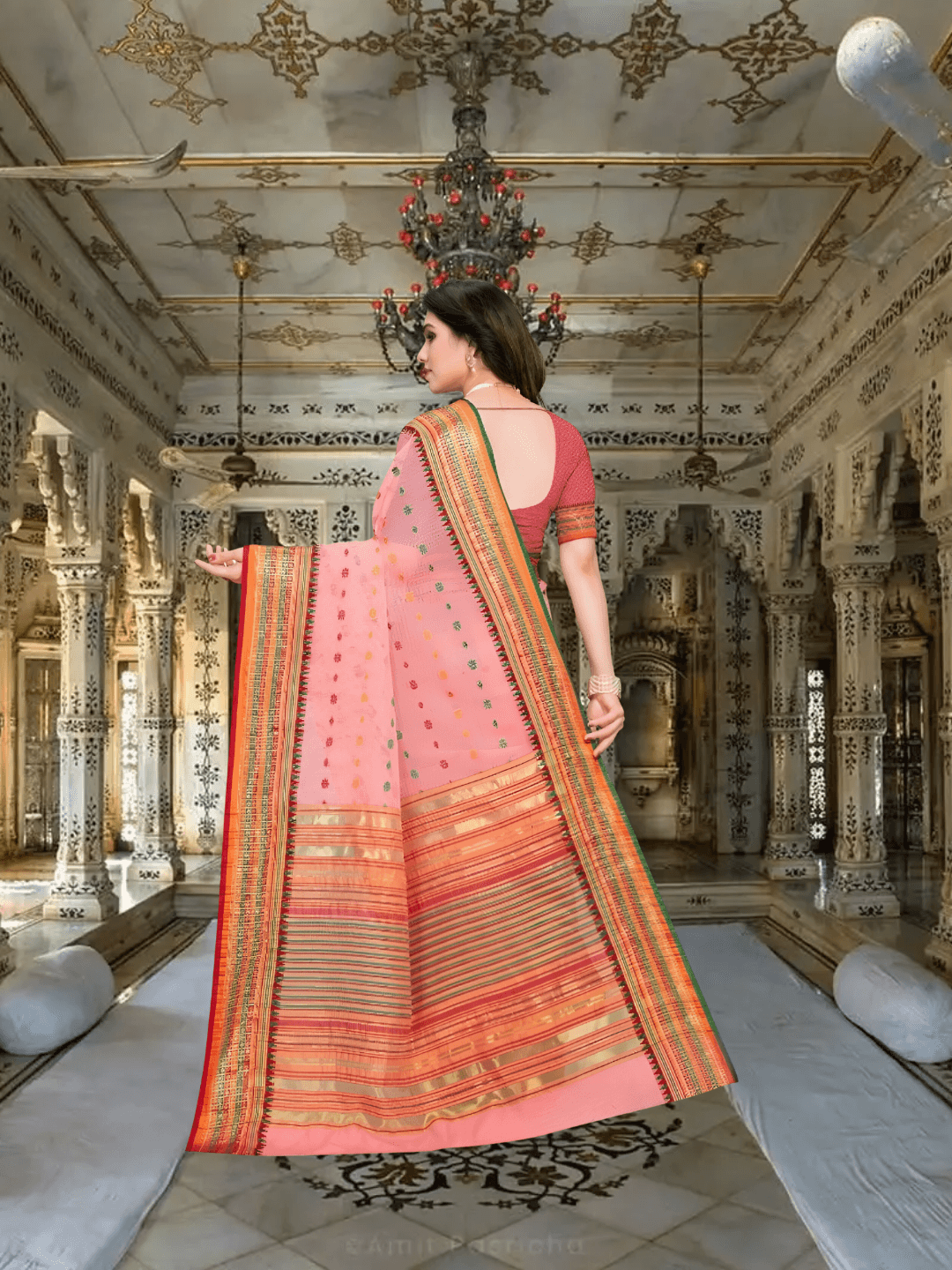 Pallu of the light pink saree flowing gently in a royal room with soft lighting