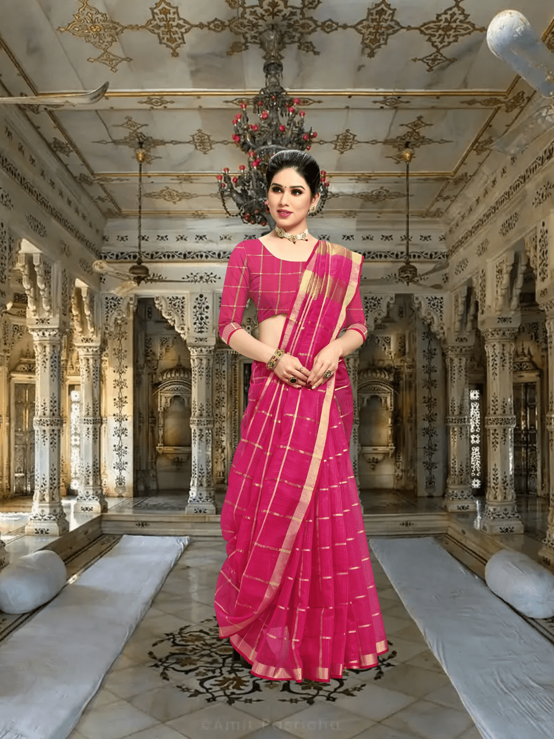 Model walking past heritage columns, saree flowing like prayer in motion, checkered pink gleaming under sunrays