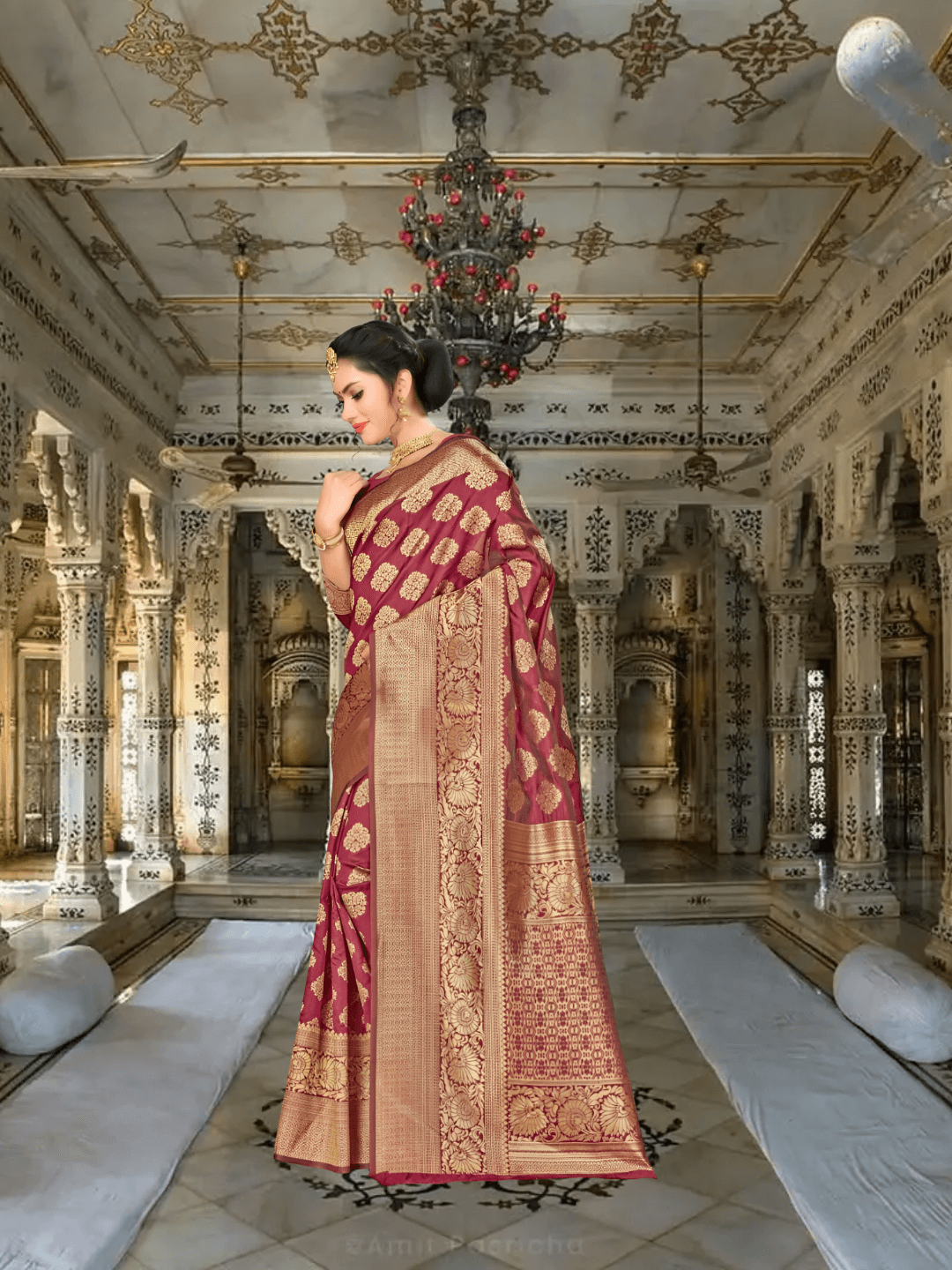 Close-up of golden abstract motifs on deep maroon silk saree in royal setup