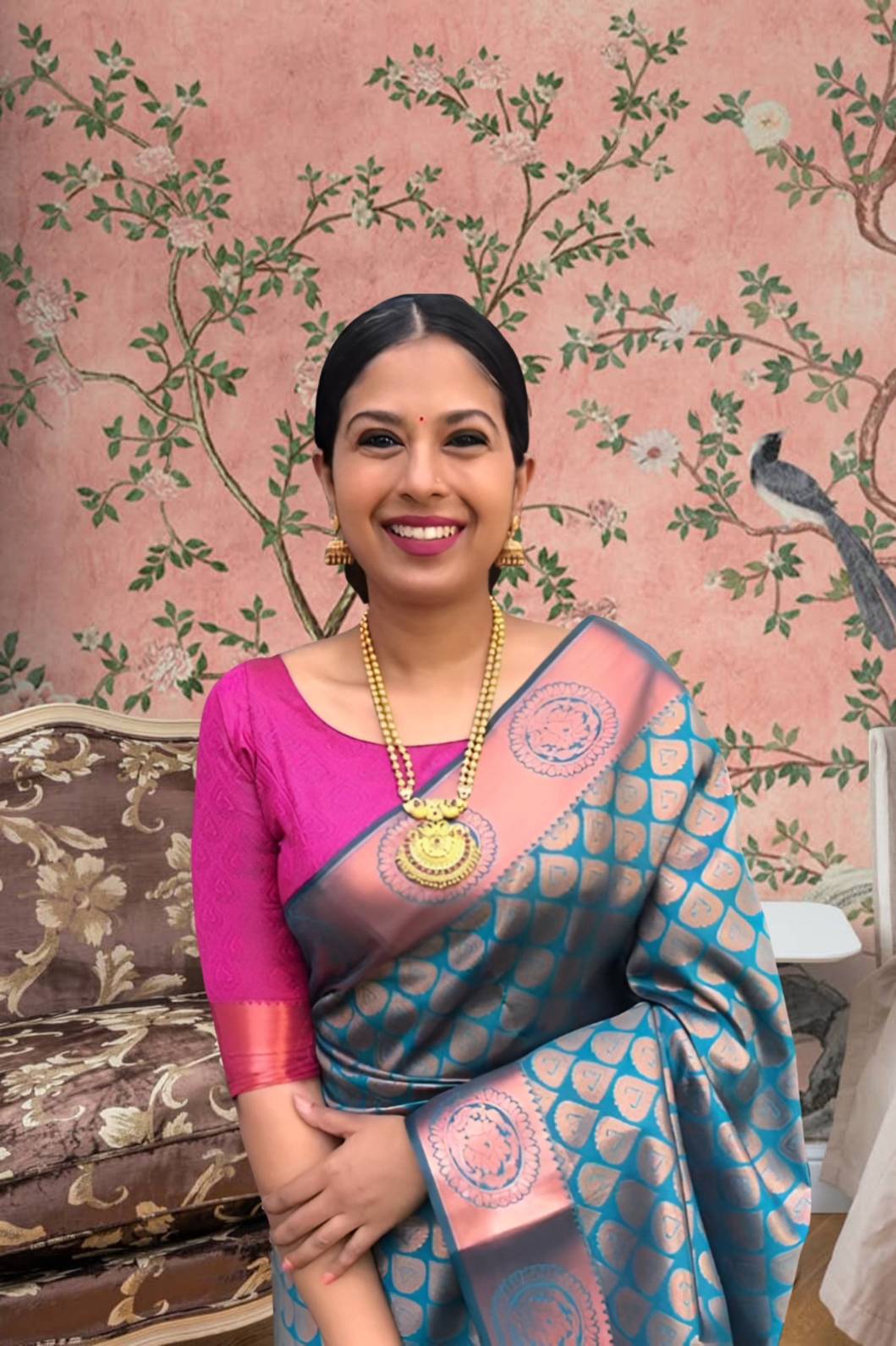 Front view of blue-green printed Litchi silk saree with pink blouse in palace setting