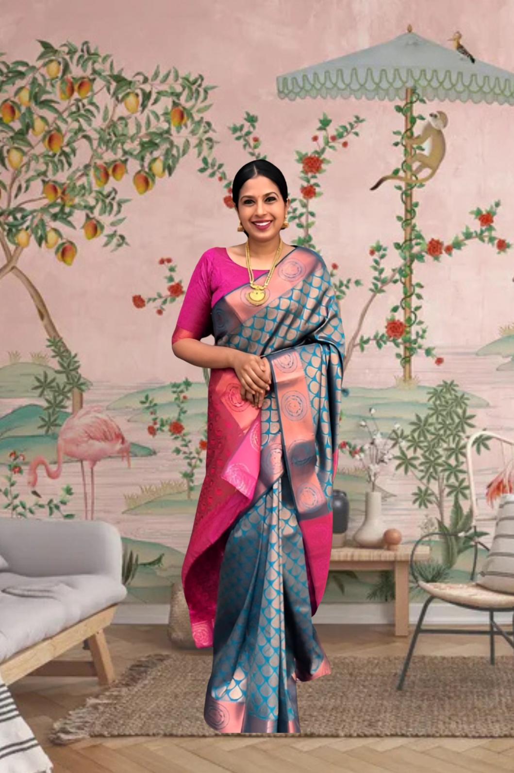 Front view of blue-green printed Litchi silk saree with pink blouse in palace setting