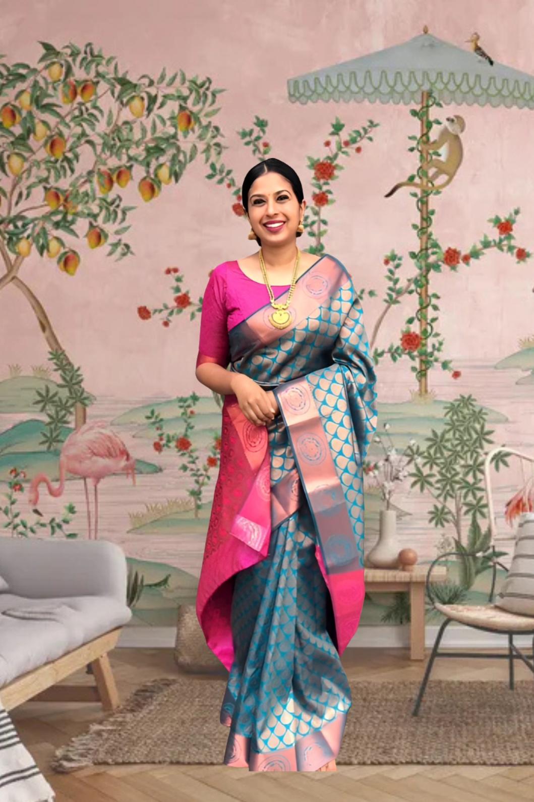 Front view of blue-green printed Litchi silk saree with pink blouse in palace setting