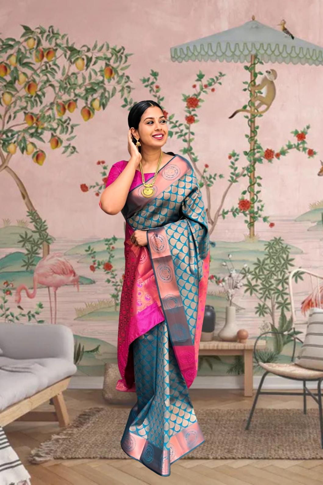 Front view of blue-green printed Litchi silk saree with pink blouse in palace setting