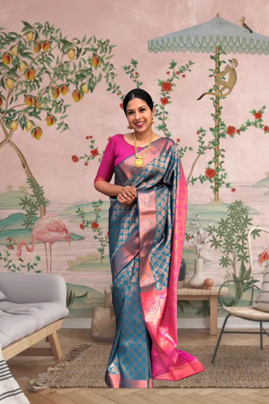 Front view of blue-green printed Litchi silk saree with pink blouse in palace setting