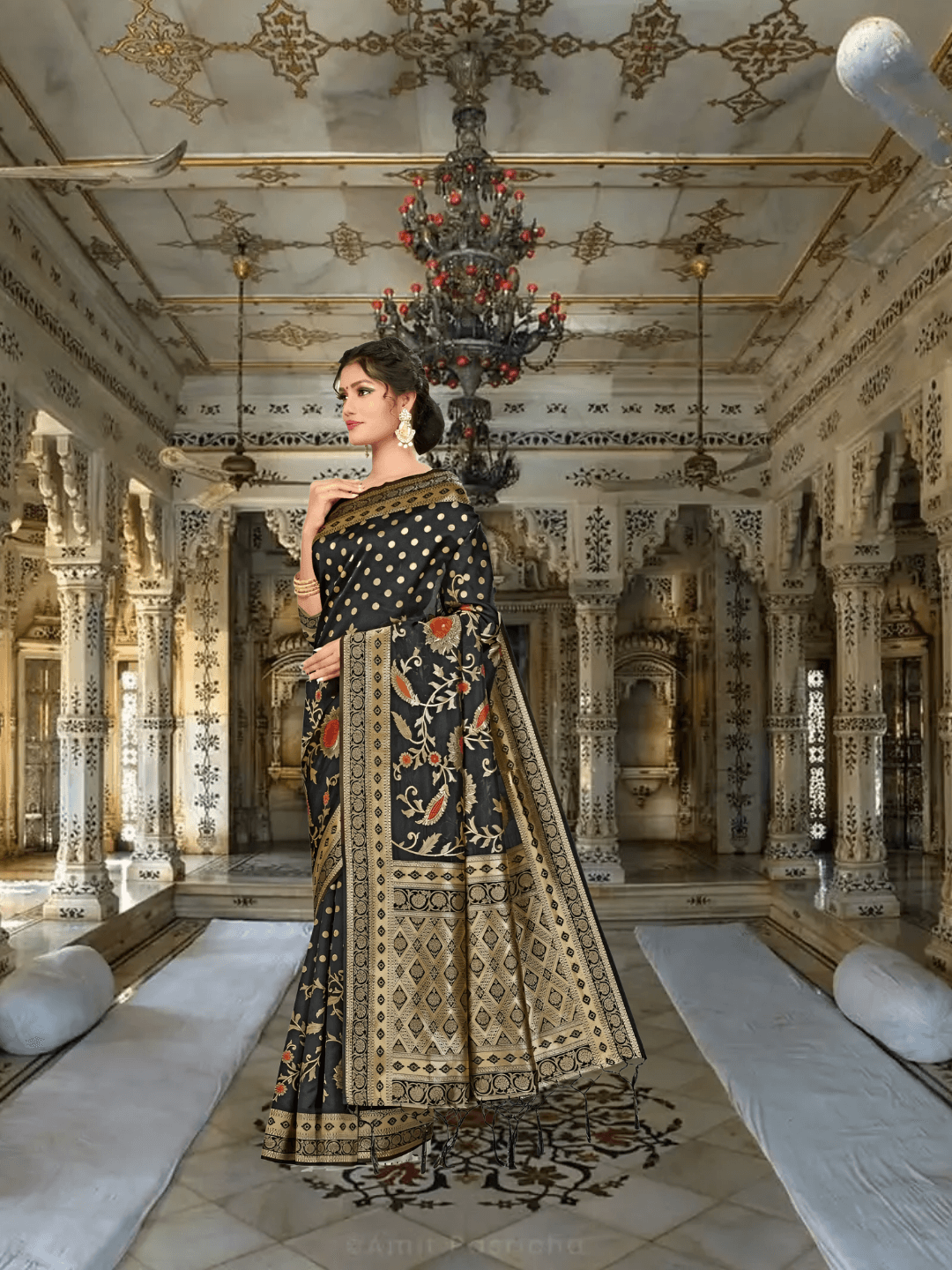 Close-up of golden abstract zari motifs on black Banarasi silk inside palace room