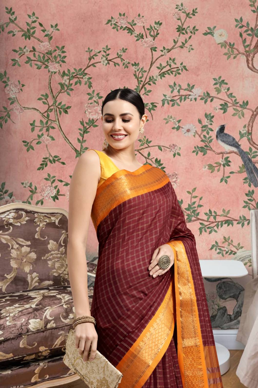 Woman draped in coffee-colored saree standing gracefully