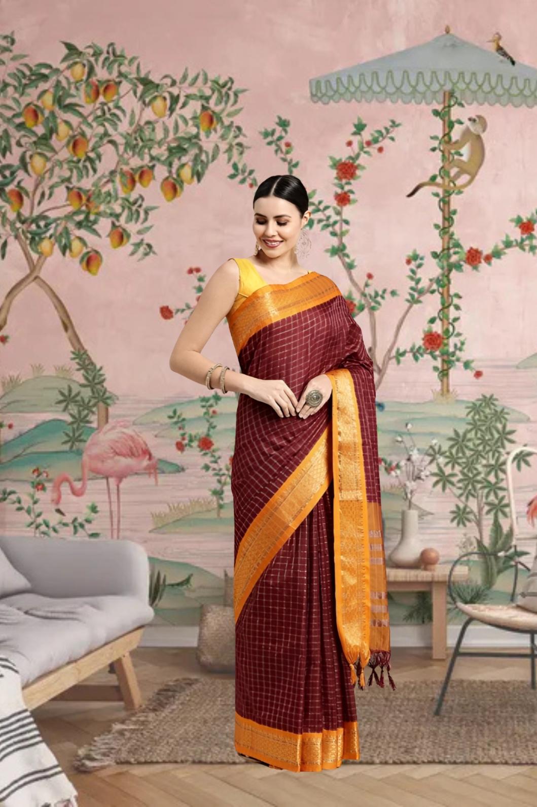 Woman draped in coffee-colored saree standing gracefully