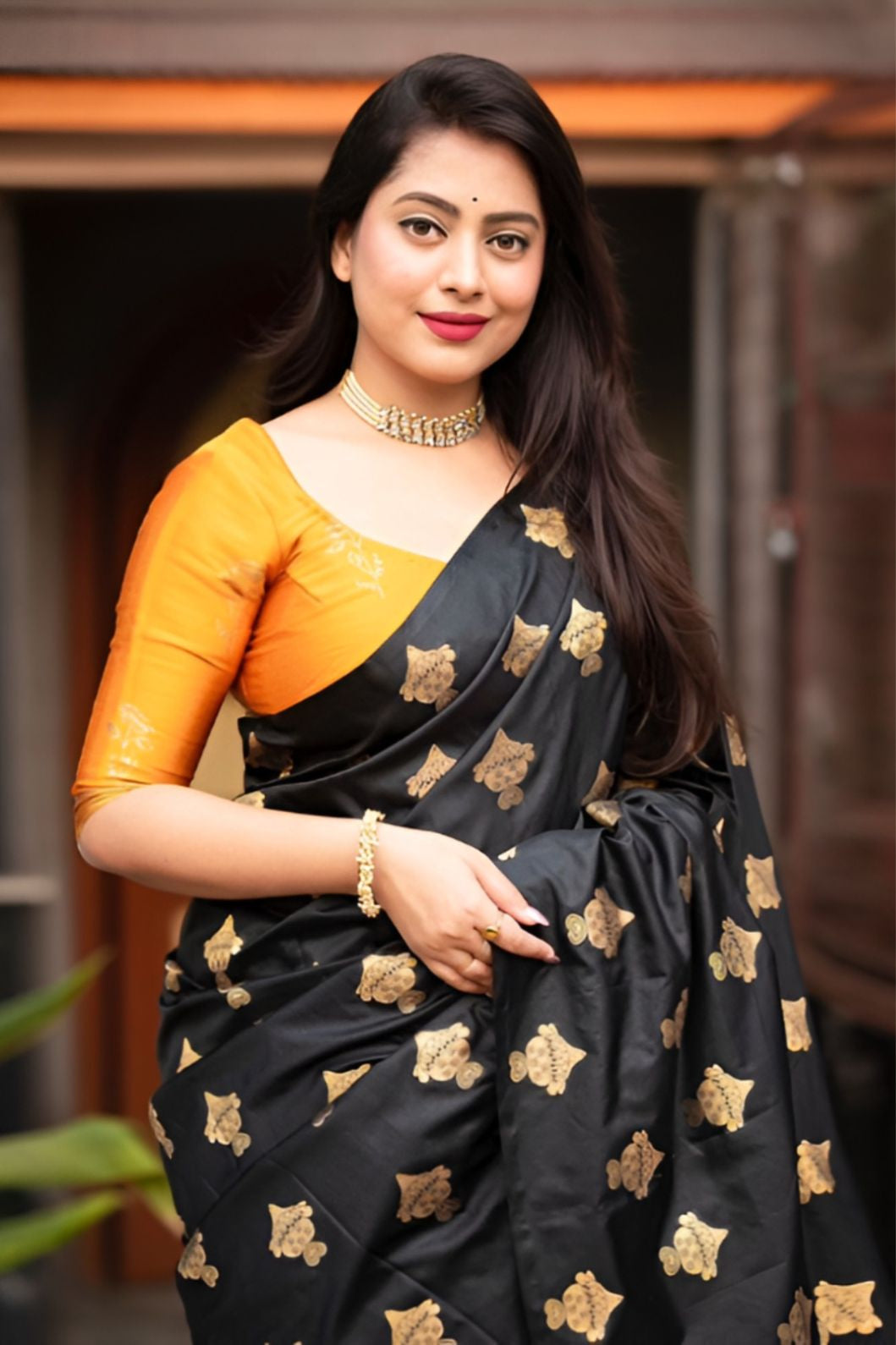Front view of black silk saree with vibrant yellow blouse in royal palace room