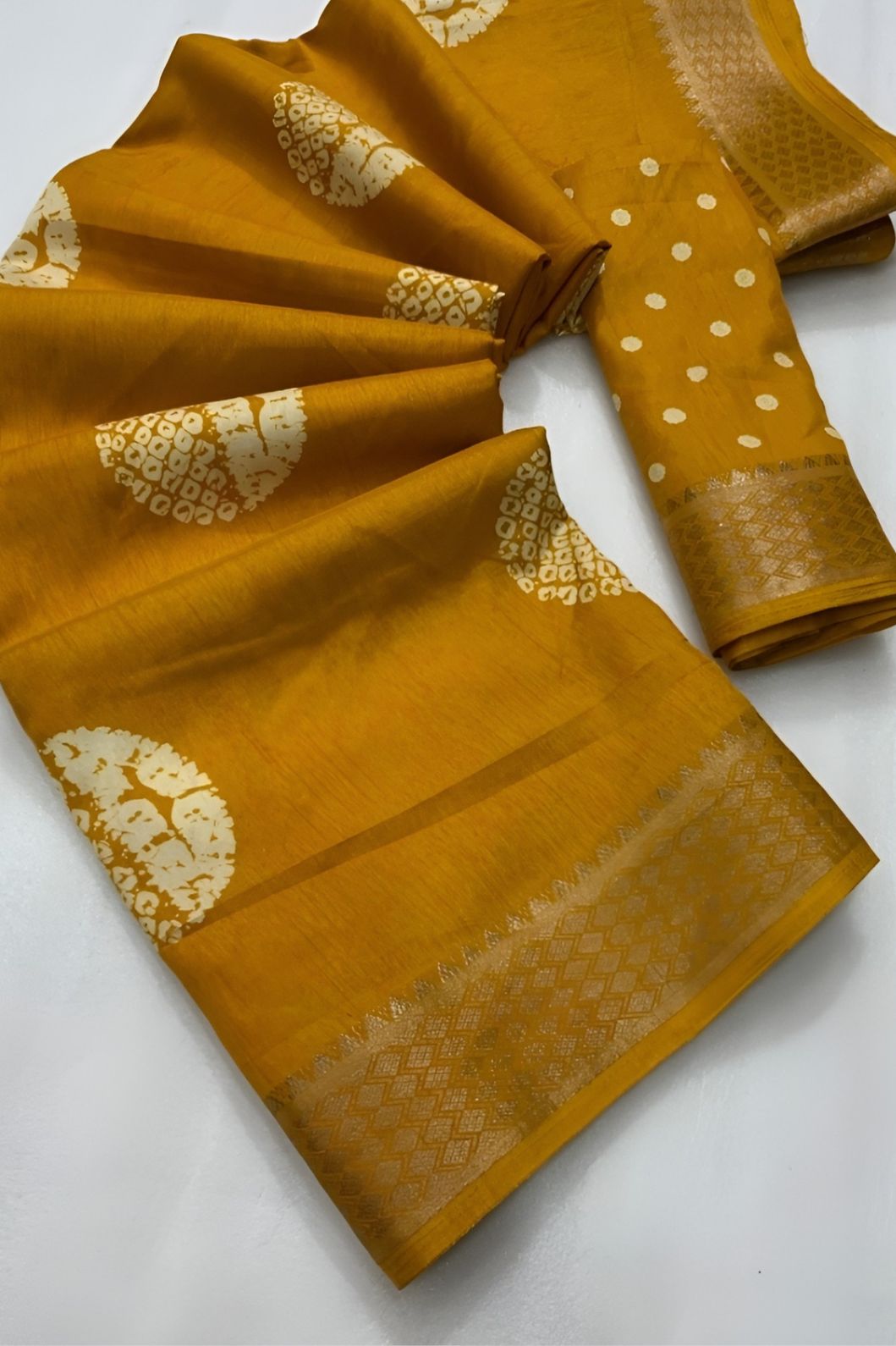 Studio close-up of yellow printed pallu and cotton crape texture