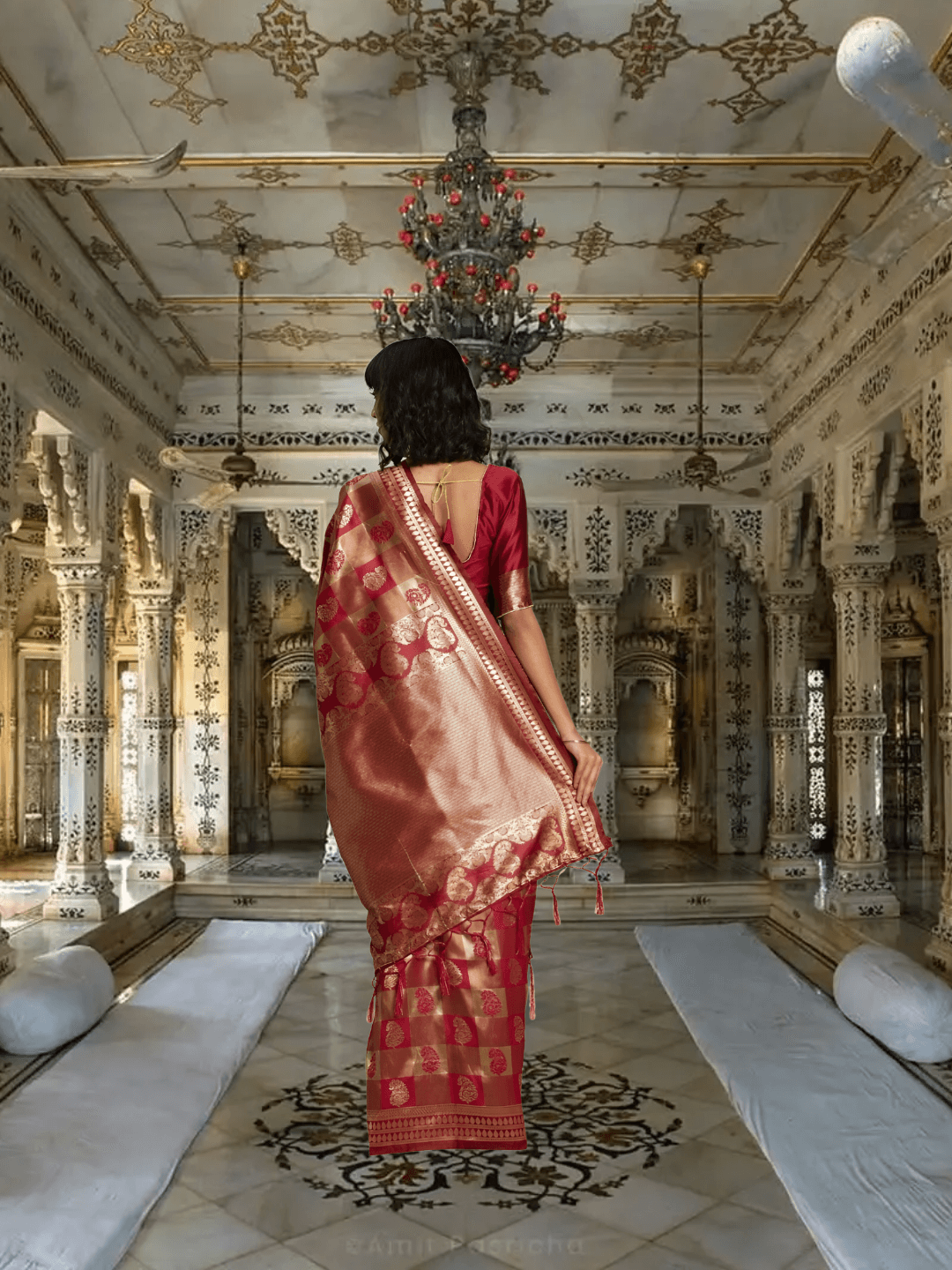 Zari pallu of maroon silk saree cascading in a regal palace room setting