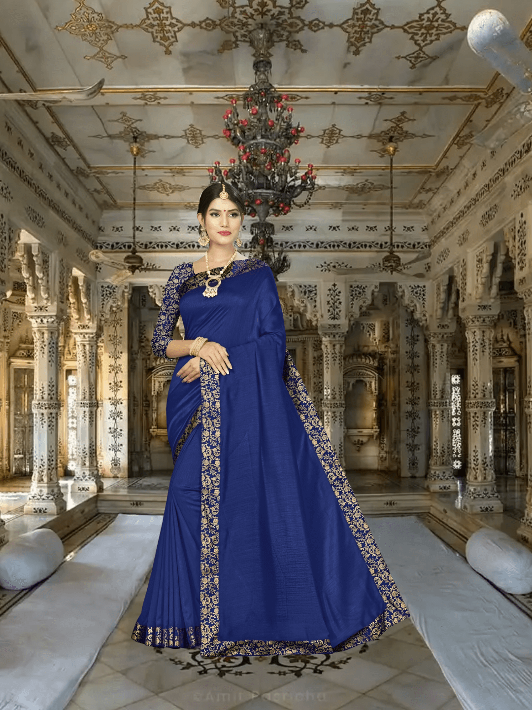 Model in navy blue silk blend saree with pink printed border in palace room