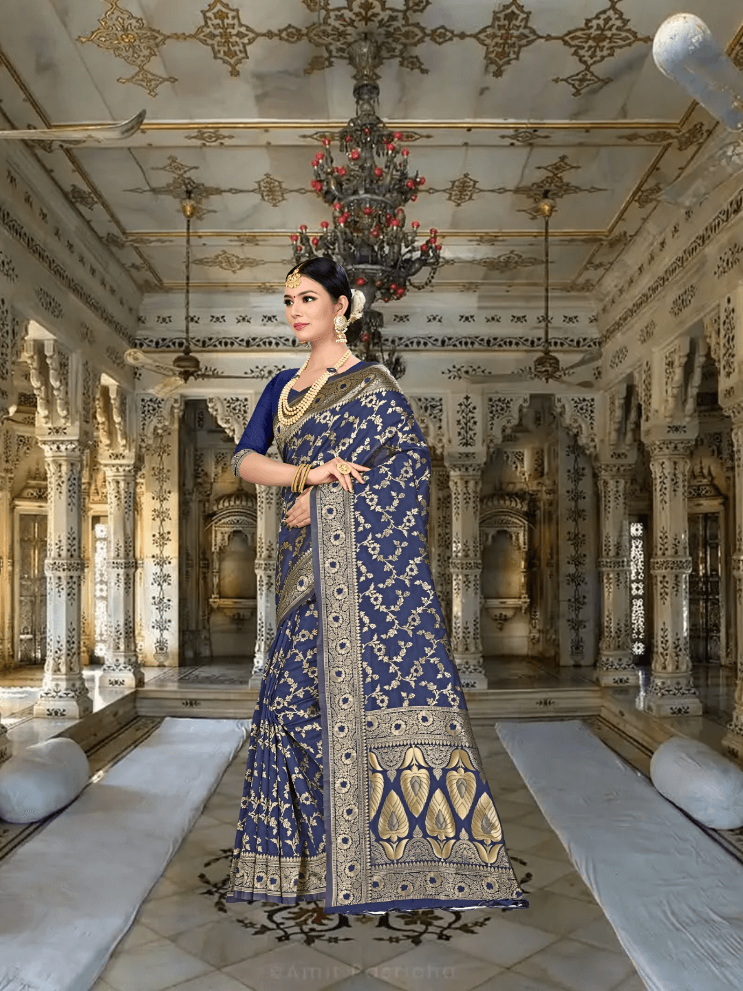Golden pallu on navy saree cascading elegantly in a regal setting