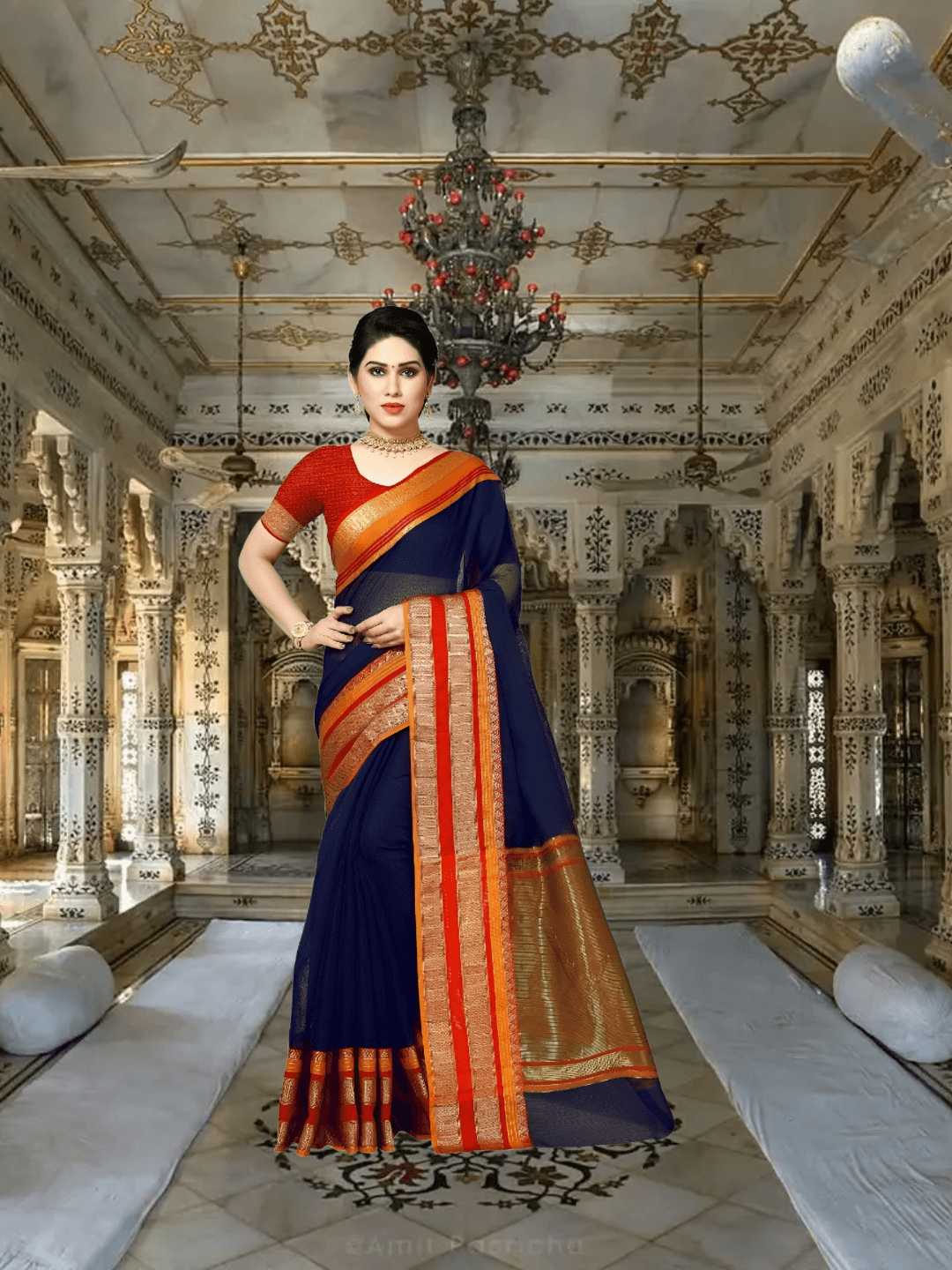 Model draped in navy saree walking through temple corridor, light glowing on golden borders