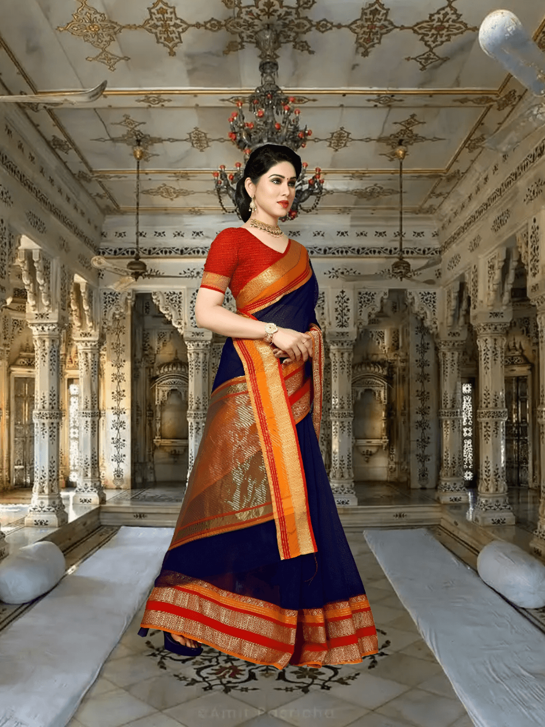 Model seated gracefully in traditional setting, saree folds fanned like poetry on stone floor