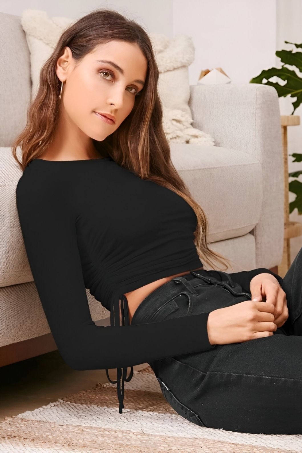 Side angle studio photo of black round neck long sleeve top