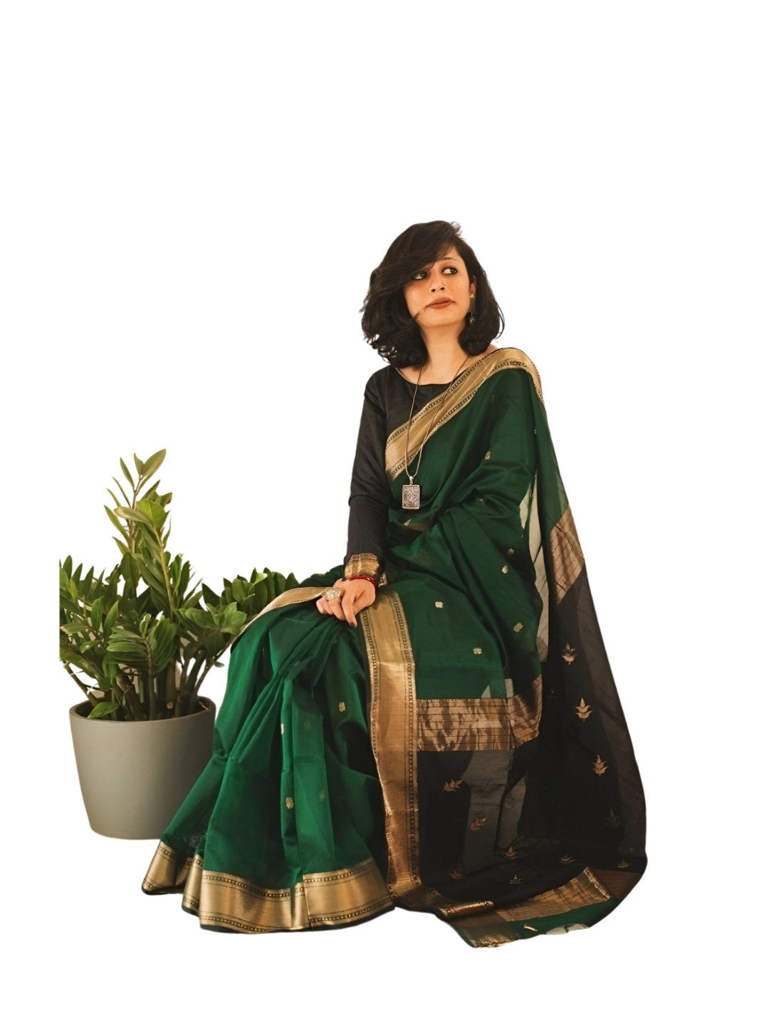 Model seated, hand resting on vintage chair