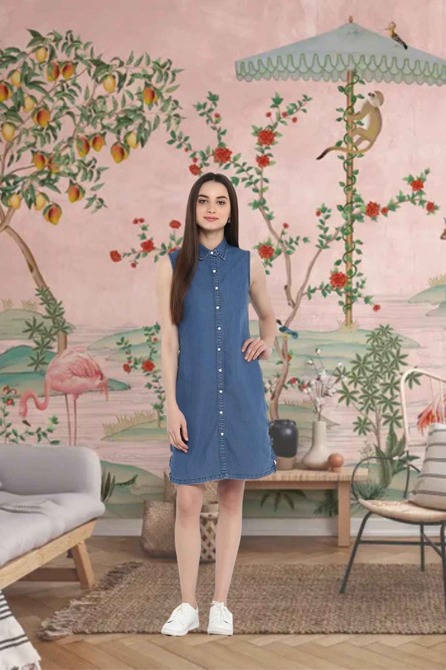 Front view of sleeveless denim dress against brick wall