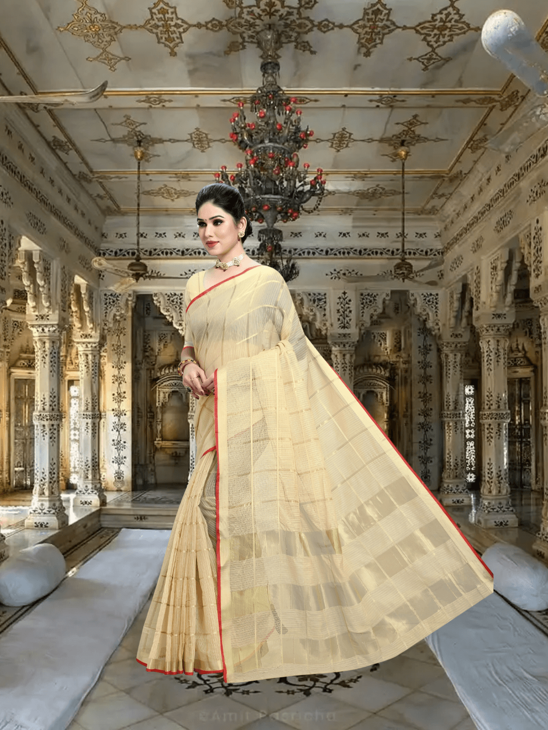 Model standing against sandstone pillar, beige saree catching sunlight like sacred dust