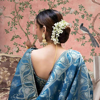 Rear angle highlighting embellished pallu in mint-toned luxury
