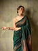 Model in a graceful green silk saree posing in palace interiors