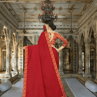 Red saree pallu cascading in regal palace room with ornate backdrop