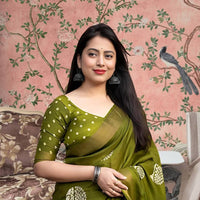 Front angle of green printed cotton crape saree glowing in regal palace light