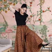 Front view of brown jaguar print palazzo pants in palace setting