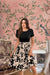 Front view of the Botanical Reverie dress with floral cream skirt and black top