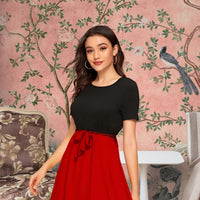 Model posing dramatically in The Carmine Waltz against elegant backdrop