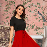 Side angle showcasing silhouette and contrast of black top with red skirt