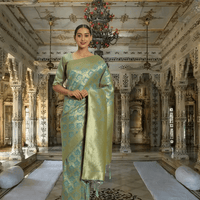Model wearing pista green Banarasi silk saree with gold border in palace setting
