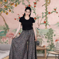 Front view of grey printed palazzo pants in palace setting