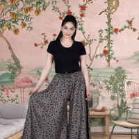 Front view of grey printed palazzo pants in palace setting