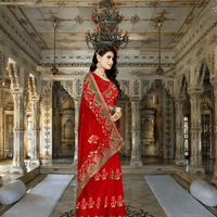 Close-up of sheer red net over hennaed hands, gold embroidery framing like antique lace