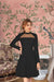 Model in black monochrome dress – soft palace lighting, poised stance