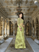 Netted pista green saree glowing under vintage palace lanterns, embroidery catching warm gold

