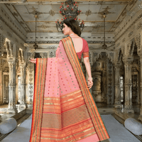 Pallu of the light pink saree flowing gently in a royal room with soft lighting
