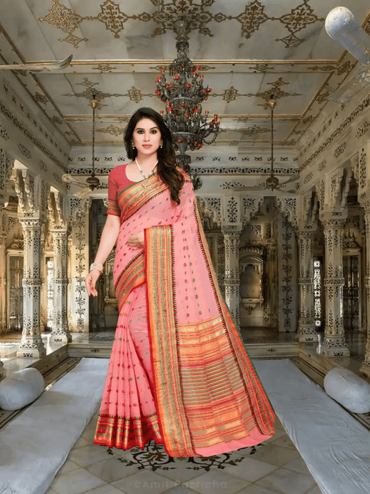 Model in soft pink saree offering side pose in a regal interior setting with poised elegance