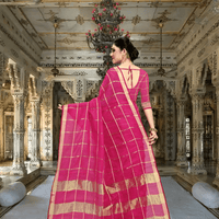 Rear pose with open pallu, red blouse creating bold contrast with soft pink body of the saree
