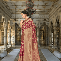 Close-up of golden abstract motifs on deep maroon silk saree in royal setup