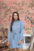 Front view of blue denim dress with rolled sleeves against wooden pier