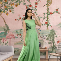 Front view of sleeveless green full-length crepe gown in palace setting