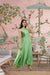 Front view of sleeveless green full-length crepe gown in palace setting