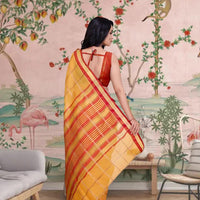 Rear profile showing flowing yellow pallu in regal ambiance