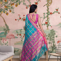 Rear profile showing flowing pallu with fine checks and heritage tone